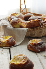 Fresh cheesecakes in a basket on a wooden table in the sun. Homemade cake. Confectionery.