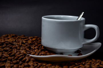 Coffee cup and coffee beans on black background