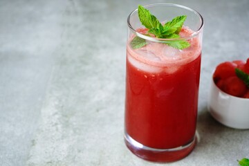 Refreshing watermelon juice in a tall glass with mint garnish,selective focus