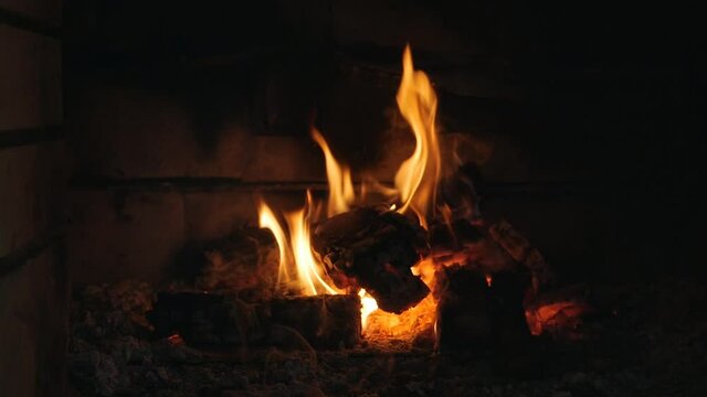Fire in the fireplace. Firewood, coal, flame. Burning Fireplace - a luminous fire in a stone fireplace to keep warm at night