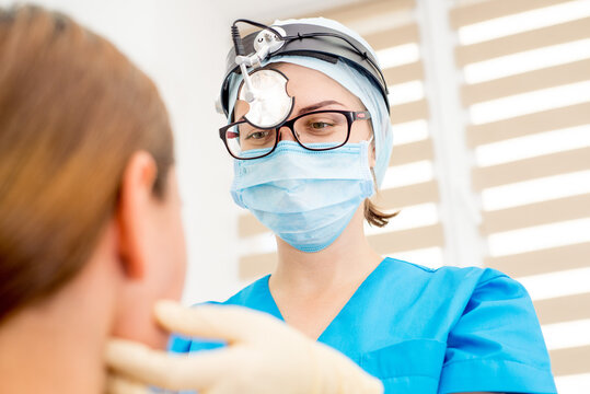 ENT Doctor With Tools, A Mask And Gloves Examines A Patient