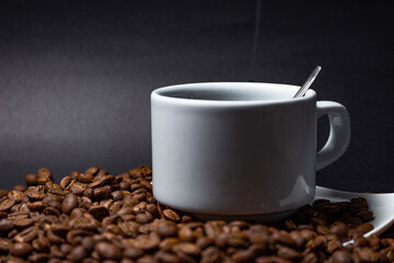 Coffee cup and coffee beans on black background