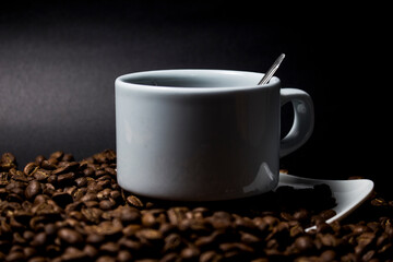 Coffee cup and coffee beans on black background
