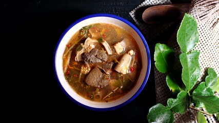 Hot and Spicy Soup with meat on the black wooden background