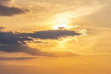 Fototapeta premium The sun shines through the evening dark clouds, the sunset.