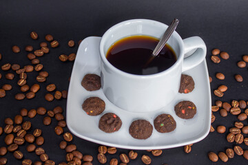 Coffee cup and coffee beans on black background