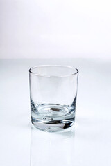 Empty glass with the air bubble in the bottom for water, juice or spirits on white background