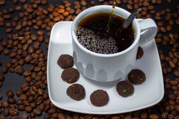 Coffee cup and coffee beans on black background
