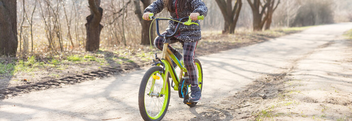 Fototapeta premium Little girl wearing anti pollution mask on her bike at park.