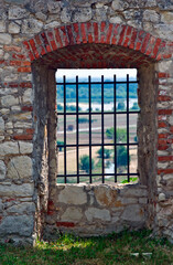 Fototapeta na wymiar A barred window in an old brick wall, Janowiec castle ruins, Poland