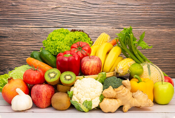 Fototapeta na wymiar Fresh vegetables and fruits With vitamins c from bananas, kiwi, grapes, raspberries, blueberries, and blackberries, good for the body and diet food on the table in nature background.