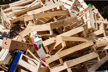 A large pile of wooden, cardboard and plastic crates on a garbage heap. Wooden and plastic and cardboard boxes from under berries on a garbage heap