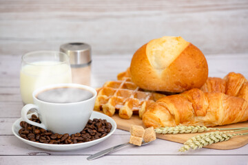 Breakfast in the morning with black coffee cup with bread with Croissant and fruit on the wooden table.