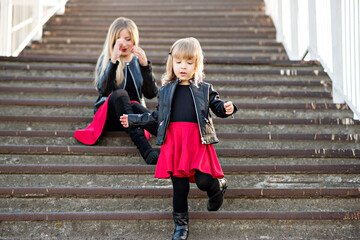 Beautiful mother blonde with red lipstick with a small daughter spend time together, walk, sit run...
