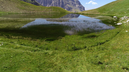 Aerial drone photo from iconic and beautiful lake Drakolimni of Tymfi mountain which resides at high altitude above sea, Vikos National Park, Zagori, Greece