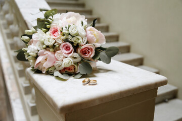 bride's bouquet and wedding rings on a bright background