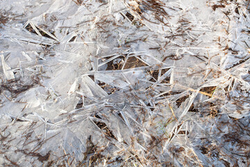fragment of frozen river surface with delicate ice cracked due weather as background