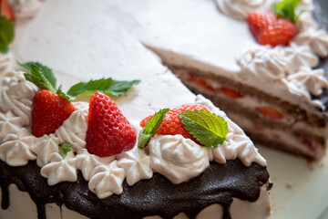 Angeschnittene Erdbeertorte mit Minze gewährt Einblick