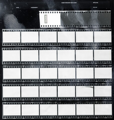 real macro photo of 35mm contact sheet with empty frames or cells on black background with grungy...
