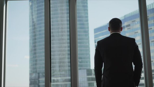 man looking on city through the window. Successful businessman in a business office.