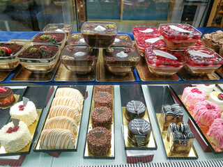 The different desserts in a pastry shop window. Sweet food.
