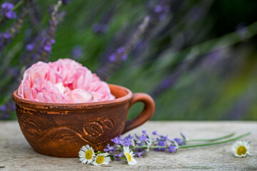 Selective focus old vintage ceramic cup of tea with flowers. Old rustic wooden table ware.