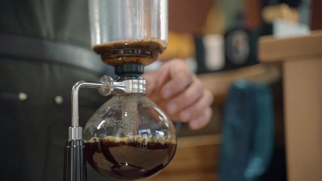 Coffee Syphon alternative method of making in coffee shop and cafe. Scandinavian coffee brewing method. Barista gets out container with coffee