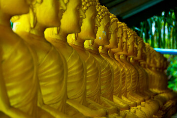 Obraz premium Golden Buddhist meditation statues at temple