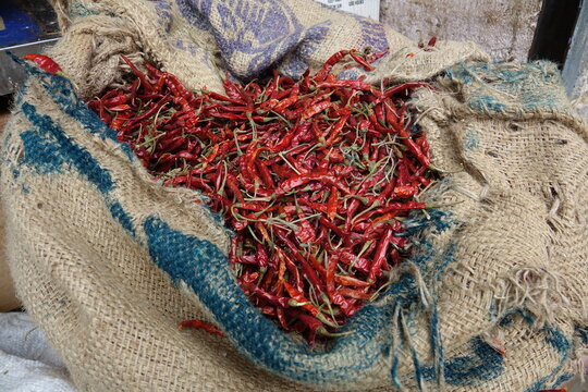 close up of a pile of chilis in woven bag