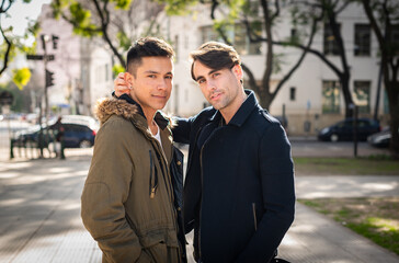 young men gay couple in the city looking at camera