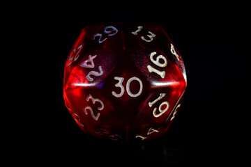 Red role playing game or rpg 30 or thirty sided dice close-up isolated on black.