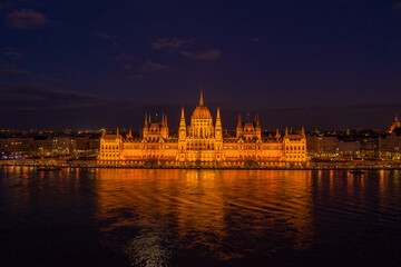 Aerial drone shot of Hungarian Parliament with lights on during Budapest evening