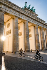 cyclists driving through brandenburg gate berlin germany © DEN