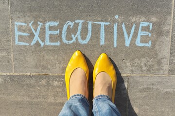 Executive concept, top view on woman legs and text written in chalk on gray sidewalk