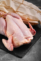 Fresh chicken carcass with tomatoes on a gray background, fresh meat, copy space, photo for grocery stores. dark background