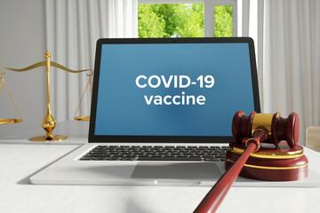 Fototapeta premium COVID-19 vaccine. Law. A lawyer laptop on a desk in the office. Text on the screen. Libra, Juctice, Web