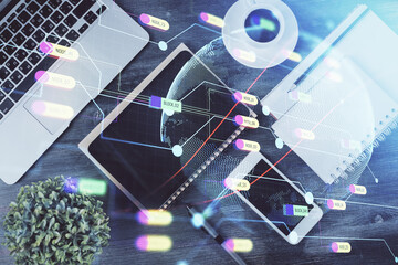 Double exposure of map hologram drawing over desktop. Top view. International connection concept.