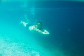 Fototapeta na wymiar Man swimming underwater