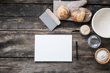 Blank paper ready for written recipe next to homemade bread and ingredients