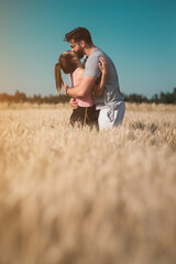 Naklejka na ściany i meble Young couple hugging in the wheat field
