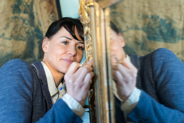 portrait of smiling woman attentively looking at painting