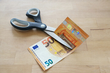 Euro banknote is cut with scissors, business concept for German lower MwSt (value added tax), wage...