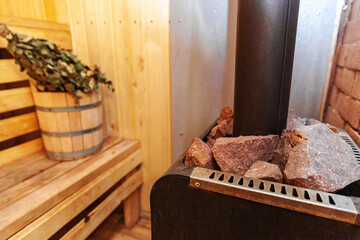 Interior details Finnish sauna steam room with traditional sauna accessories basin birch broom. Traditional old Russian bathhouse SPA Concept. Relax country village bath concept.