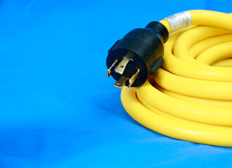 Yellow electric cable on  blue background, selective focus