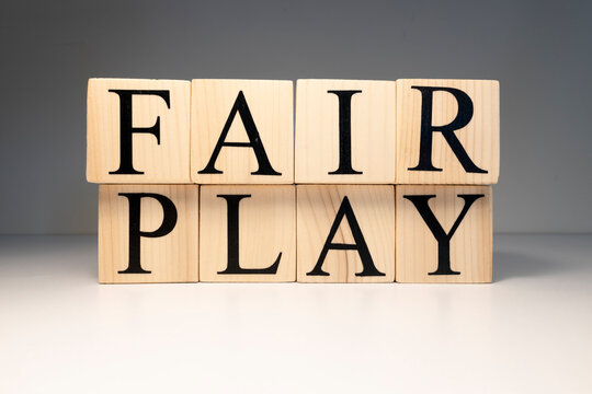 Fair play word from wooden cubes. Spotlight and white background.