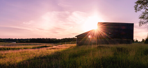 An old barn under sunset with sunburst, sunstars