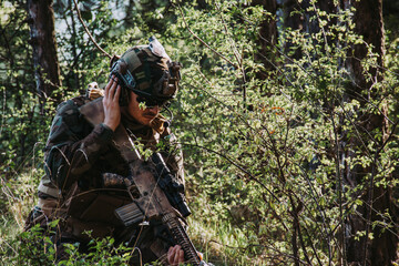 	
Soldier in a forest hiding in a foliage. Full equipment. soldier concept	
