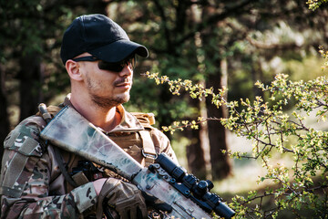 Soldier in a forest hiding in a foliage. Full equipment. soldier concept