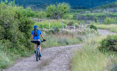 young guy rides a mountain bike on a summer afternoon