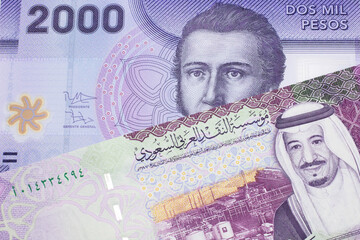 A purple two thousand peso bank note from Chile with A colorful five Saudi riyal bank note close up...